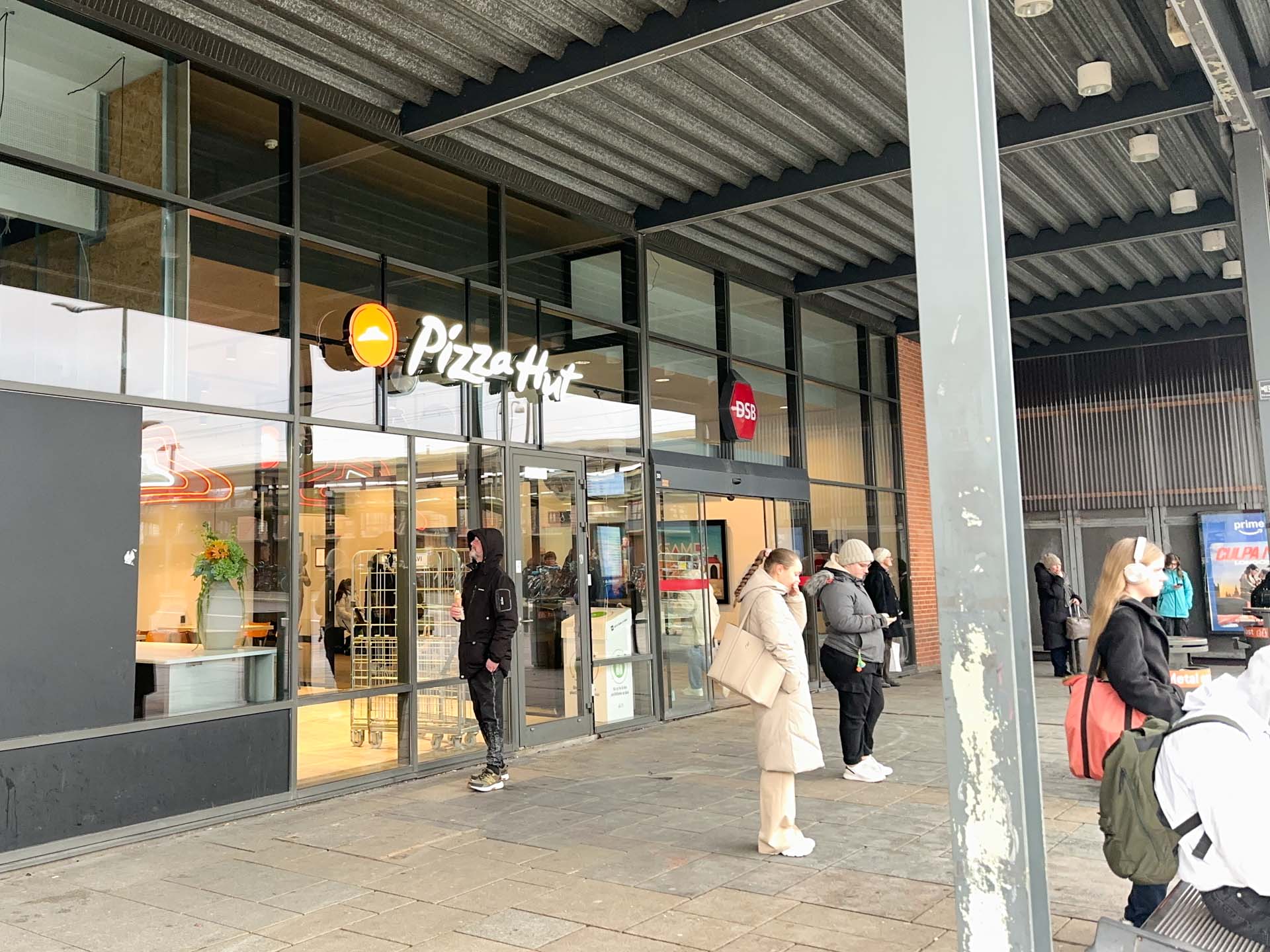 Pizza Hut ligger i ankomsthallen i Vejle Trafikcenter på Banegårdspladsen.